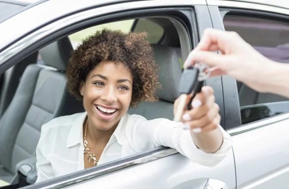 Guest handing car keys out the window to a valet attendant